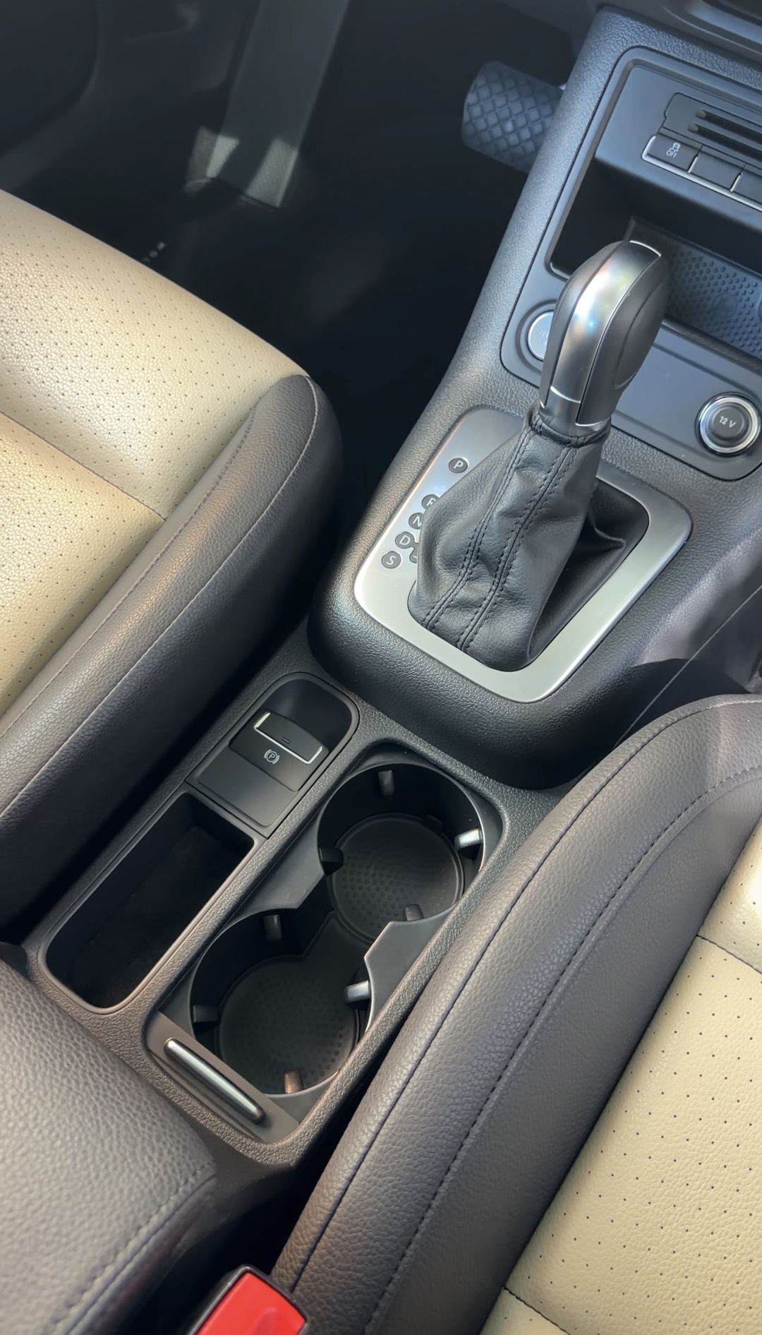 Centre console and cupholders of a VW Tiguan after detailing, tray and cupholders clean.