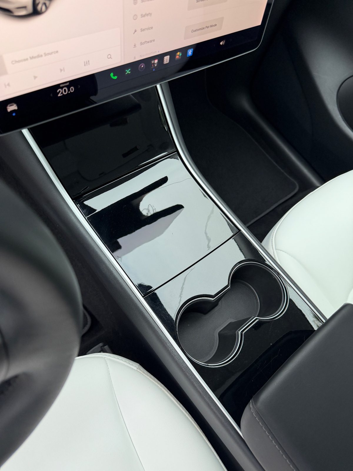 Clean centre console and cupholder of a white Tesla Model Y after detailing