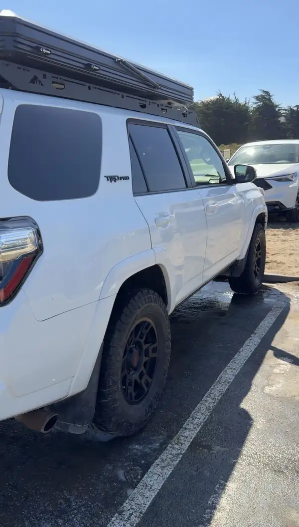 Passenger-side rear three-quarter view of a clean white Toyota 4Runner TRD Pro with black wheels