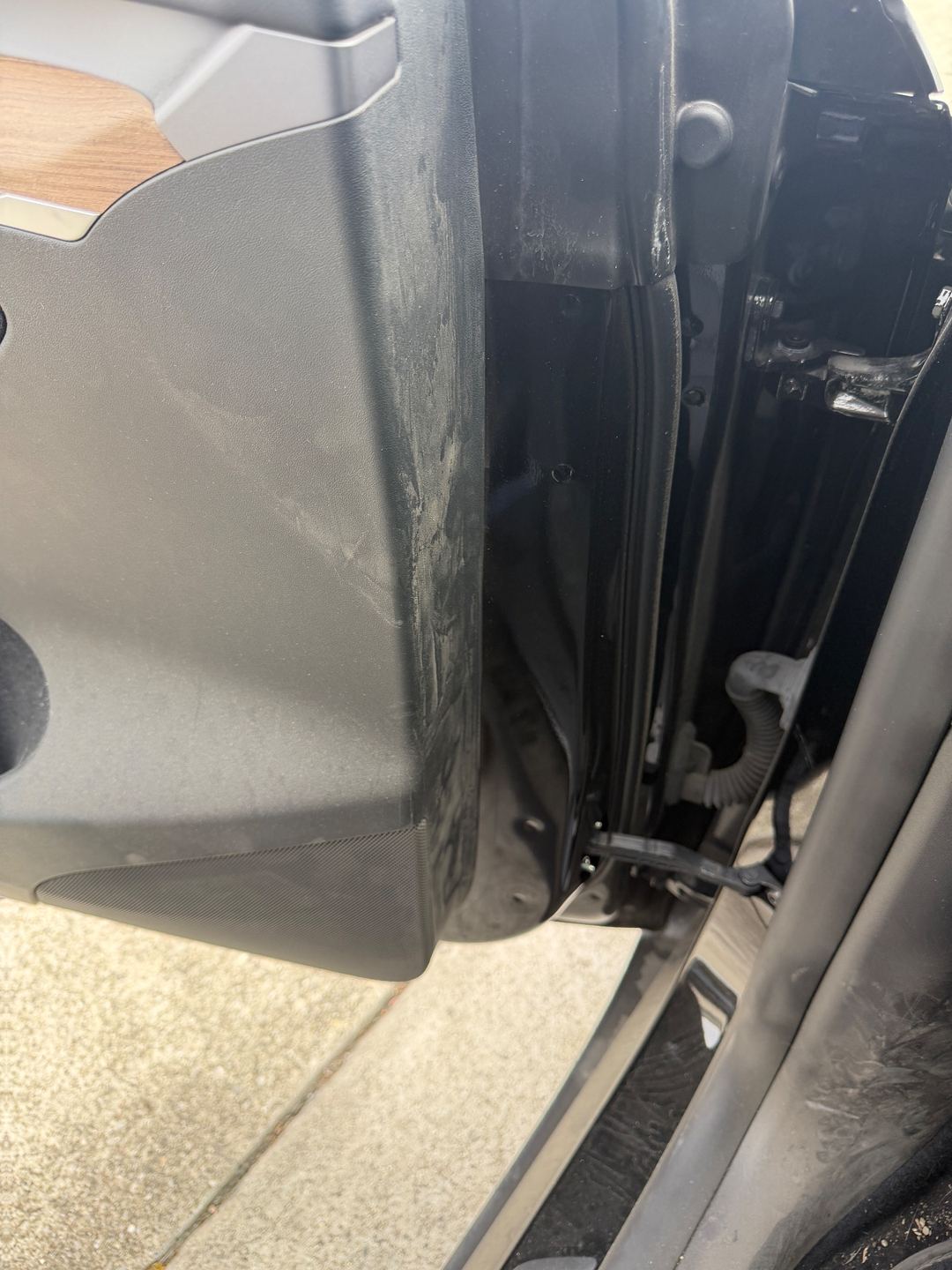 Lower door panel and door jamb of a Tesla Model Y before detailing, scuffed and dusty