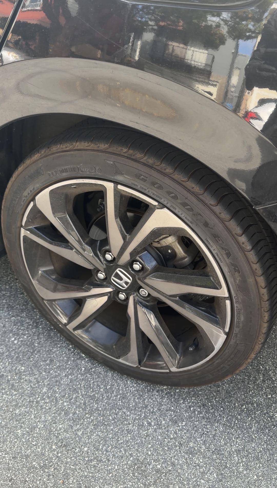 Dirty rear wheel and faded tyre on a black Honda Civic before the detail