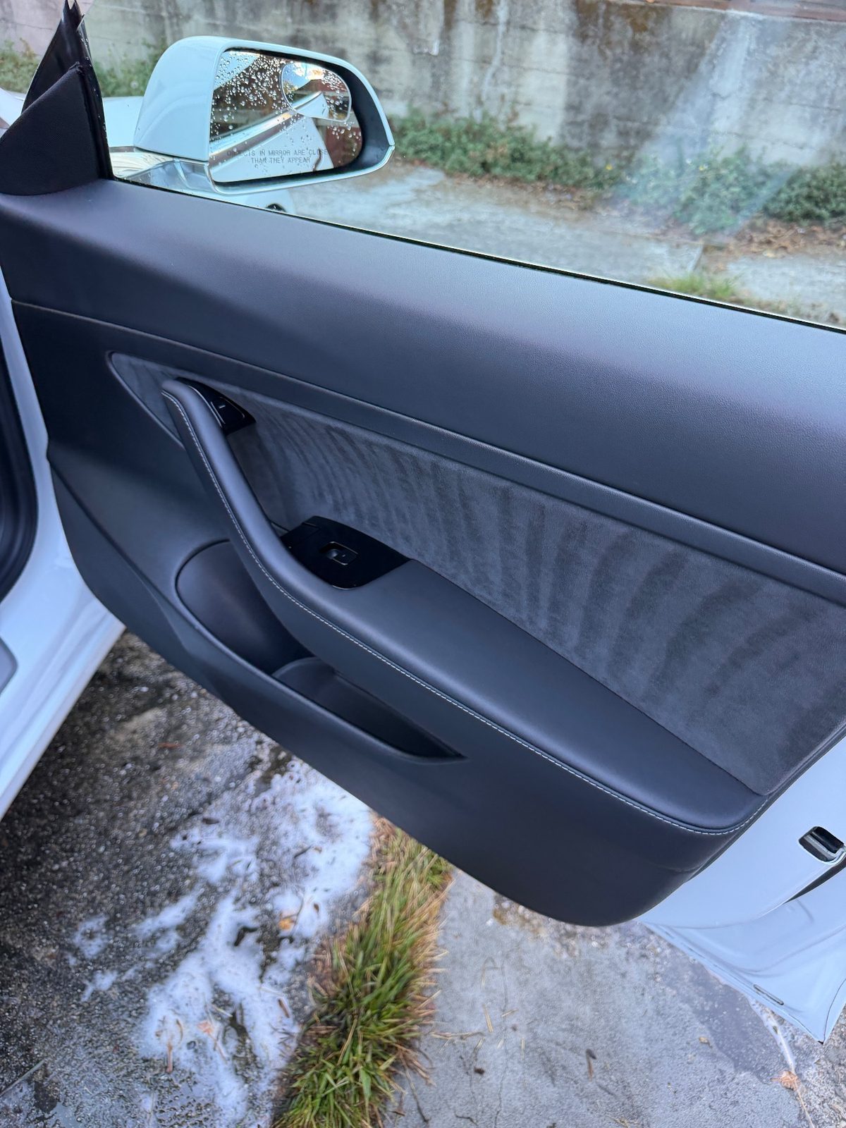 Clean door card of a white Tesla Model 3 after detailing
