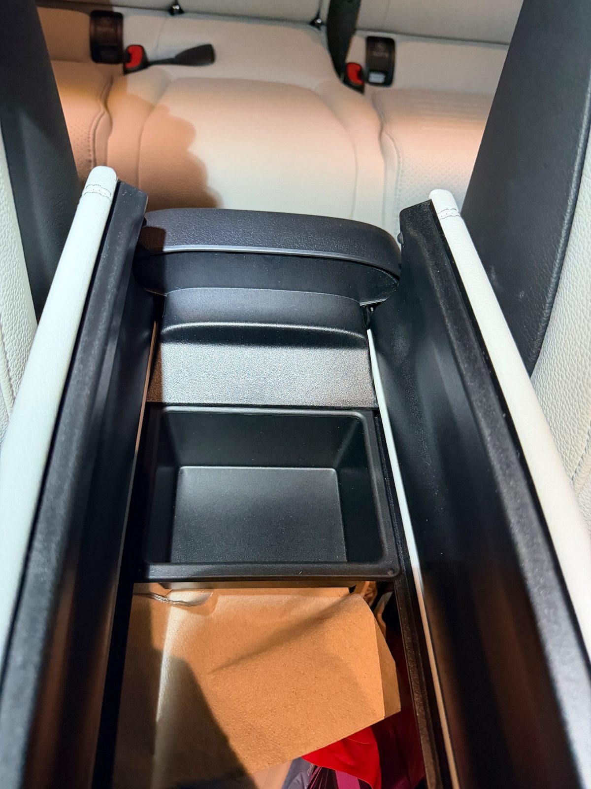 Opened centre armrest bin of a white Mercedes GLC after cleaning, clean black tray
