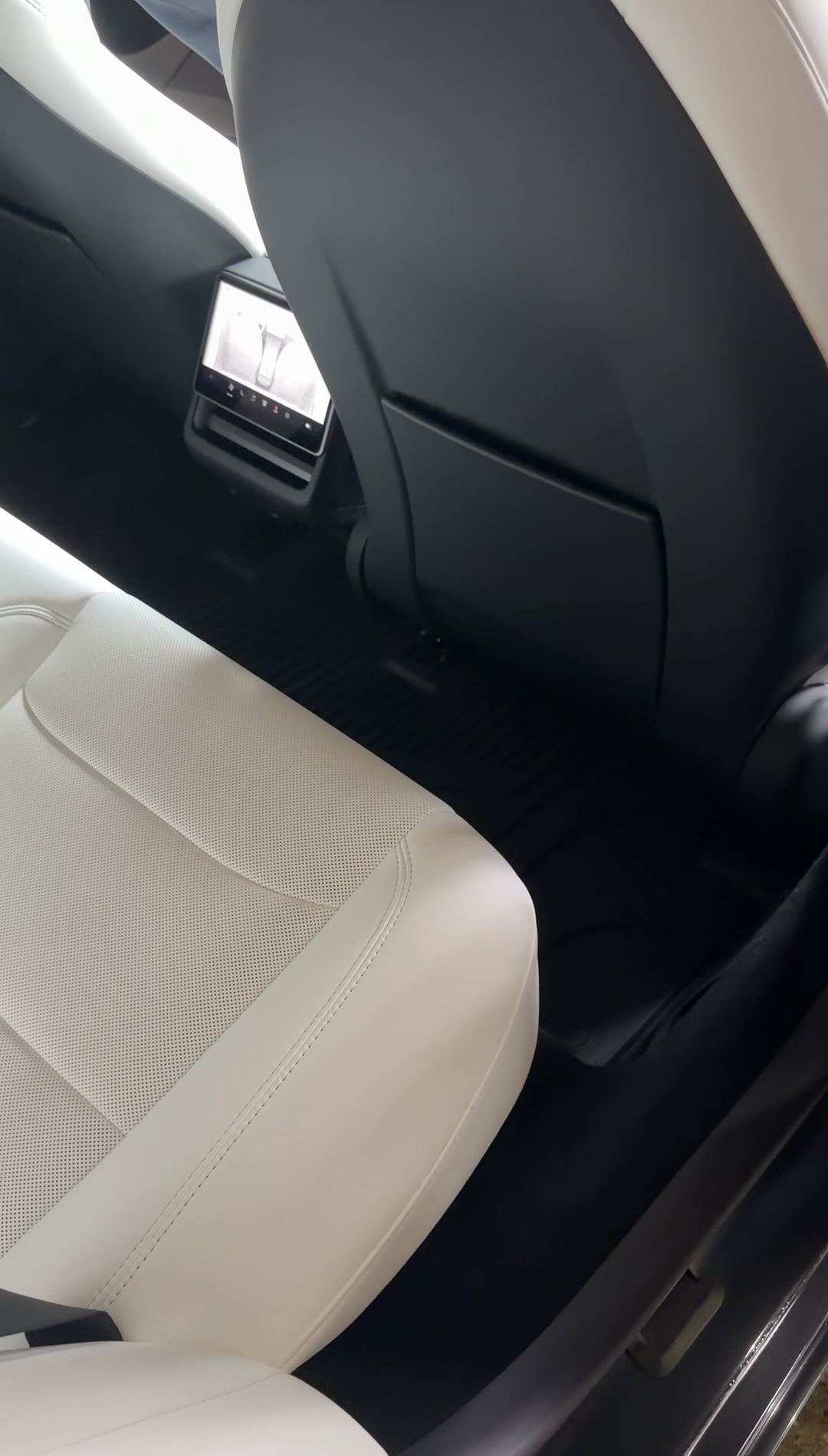 Cleaned cream leather rear seat and footwell of a Tesla Model 3 after detailing