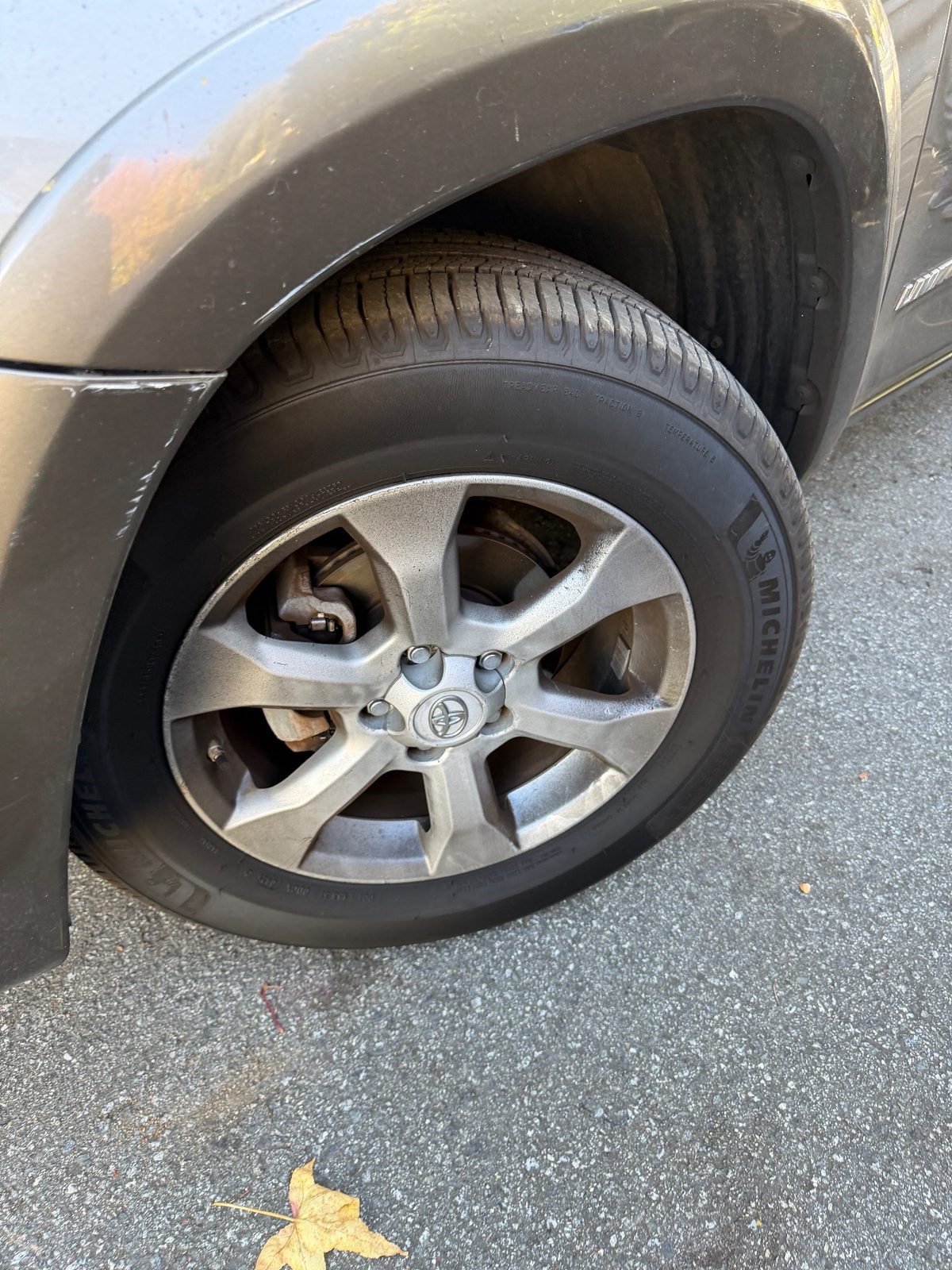 Front wheel and fender of a bronze Toyota RAV4 in the Inner Sunset, San Francisco, before detailing