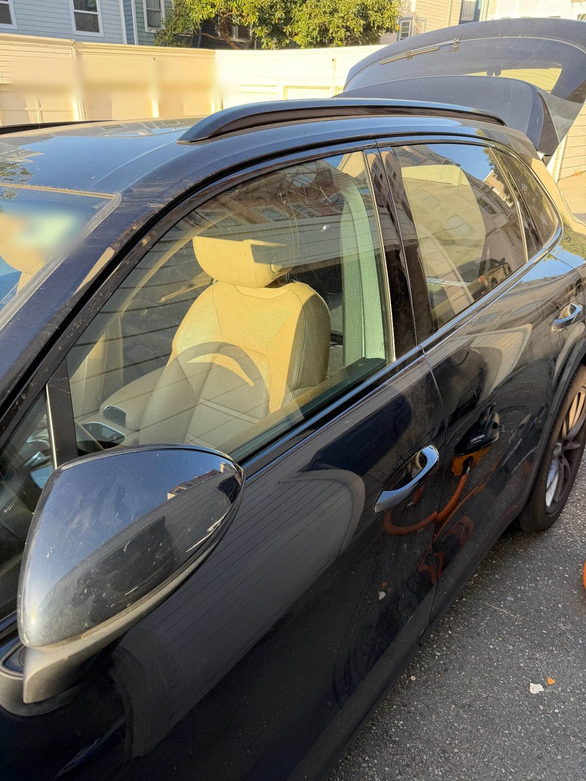 Side of a dark blue Porsche Cayenne before washing, dusty mirror cap and side glass