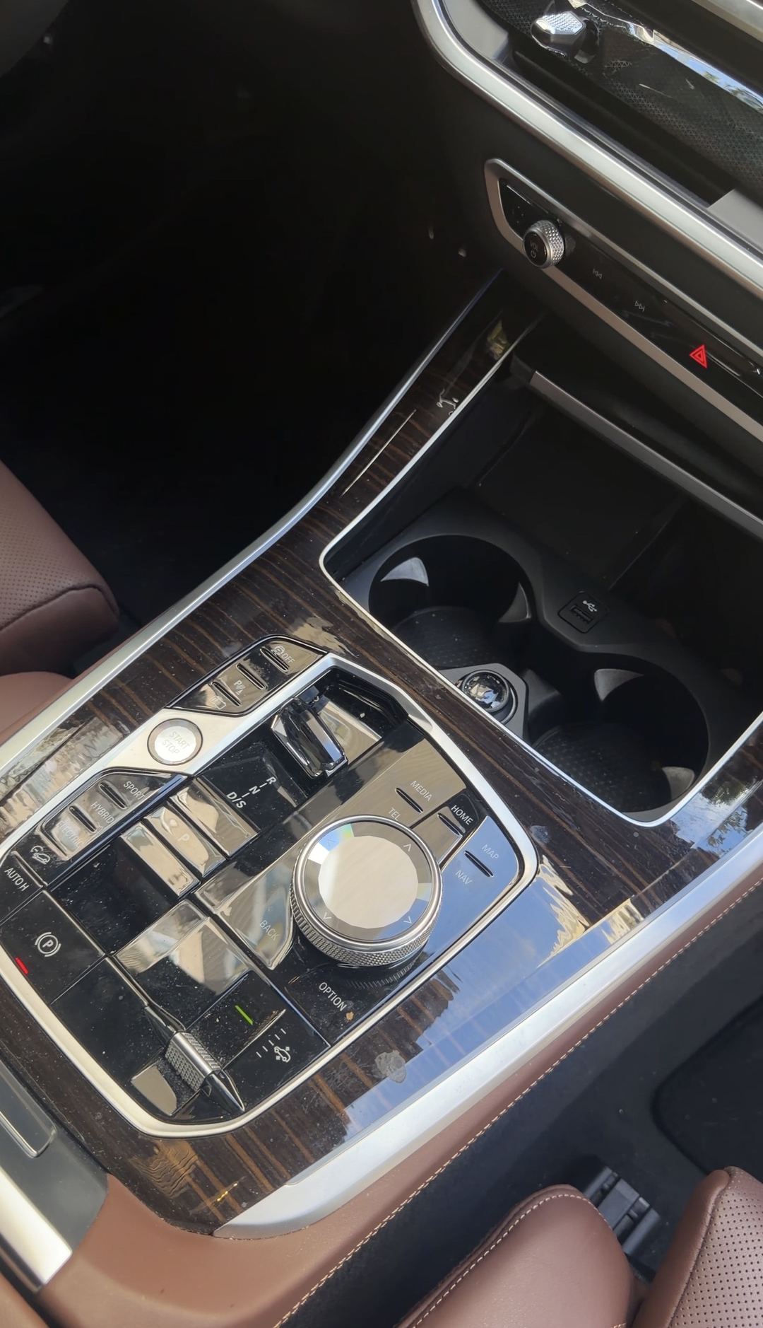 Dusty centre console of a BMW X5 before interior detailing, showing the electric and hybrid drive-mode buttons