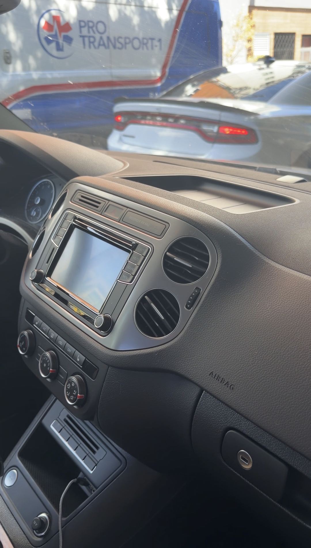 Centre stack and dashboard of a VW Tiguan before detailing, seen from the passenger side.