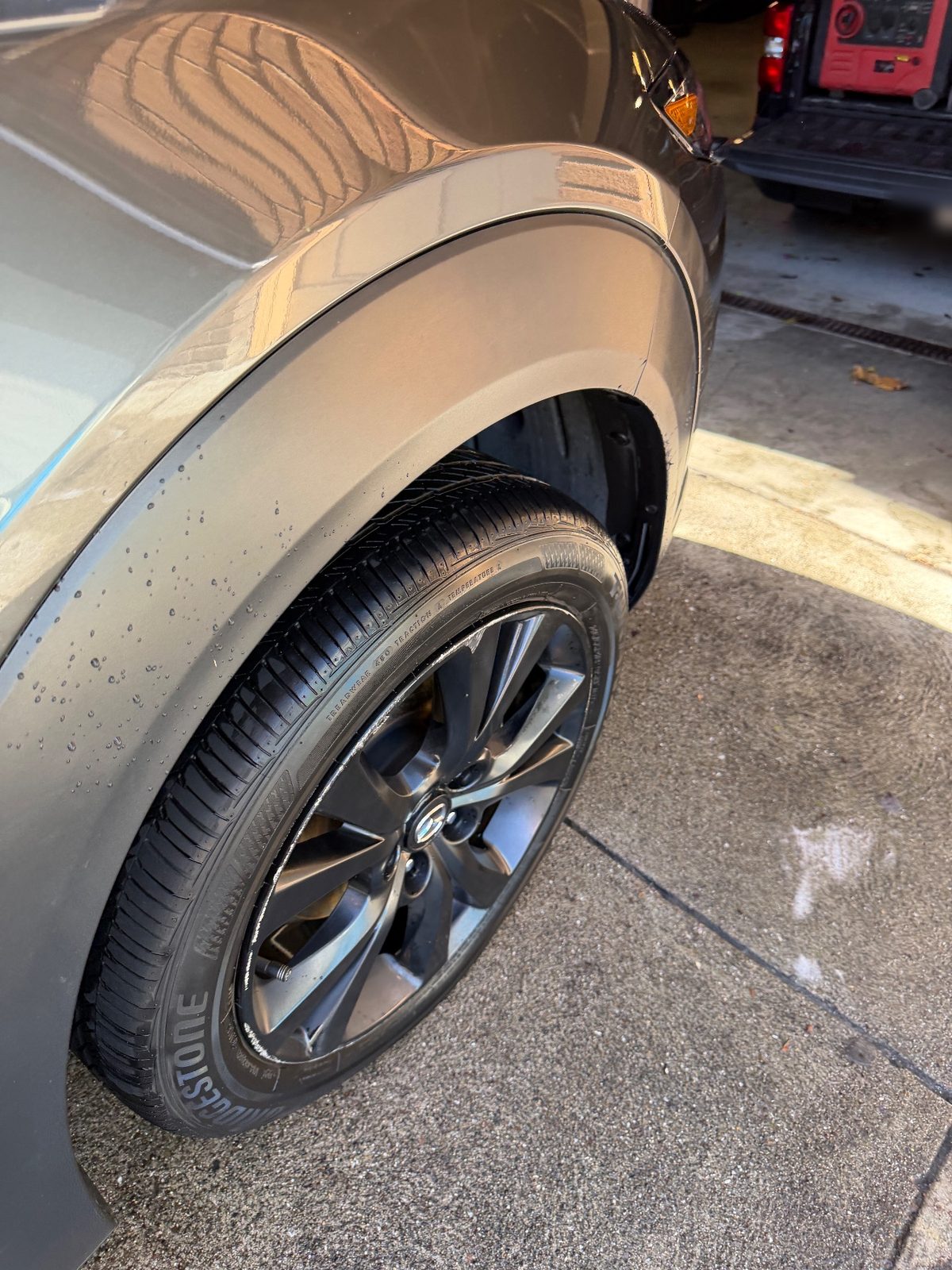 Front wheel and arch of a grey Mazda CX-30 after cleaning, tyre dressed and flare clean