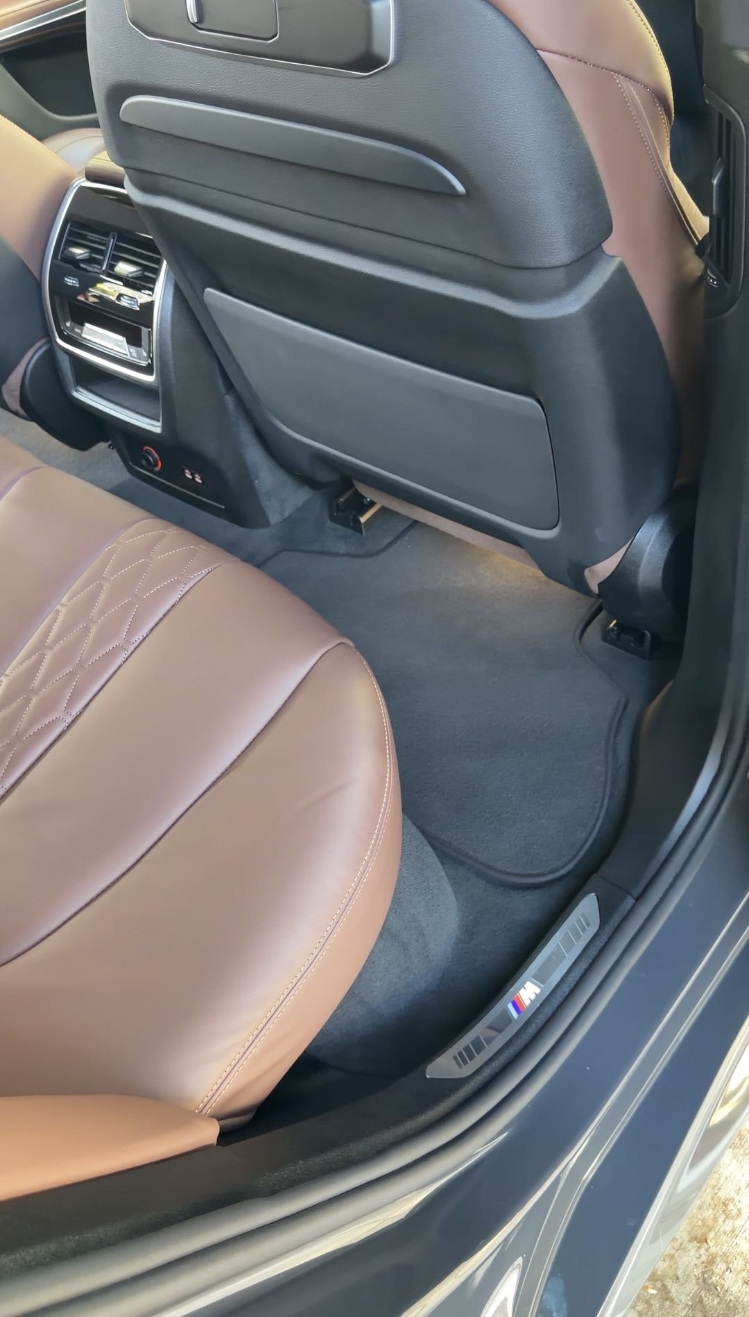 Rear passenger footwell of a BMW X5 after vacuuming, the floor mat clean and the carpet freshly napped