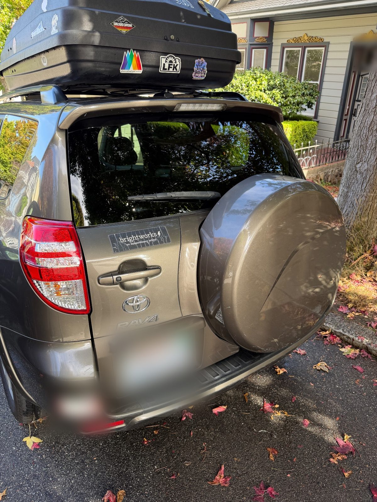 Clean glossy rear of a 2011 Toyota RAV4 after detailing with roof box and spare cover