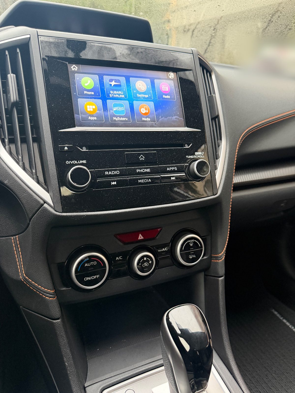Dusty infotainment screen and climate controls in a Subaru Crosstrek before cleaning