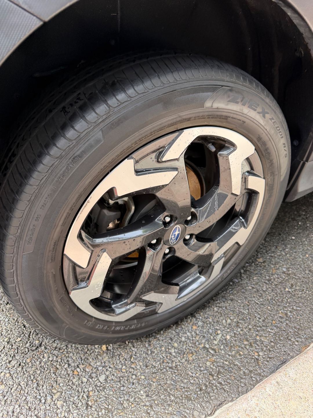 Clean alloy wheel and dressed tyre of a Subaru Crosstrek after washing, water beading on the spokes