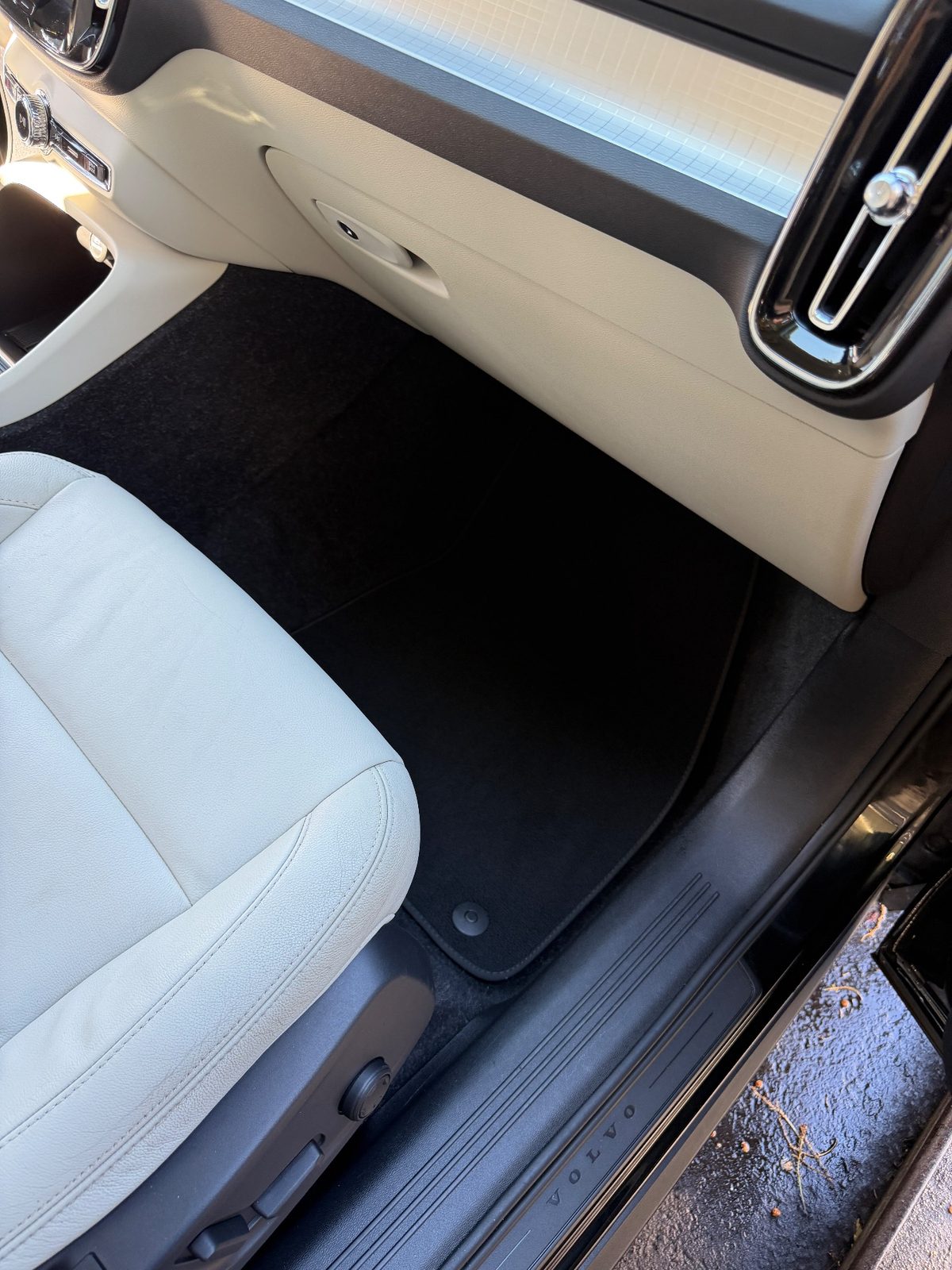 Clean front passenger footwell of a Volvo XC40 after detailing, with a clean black mat