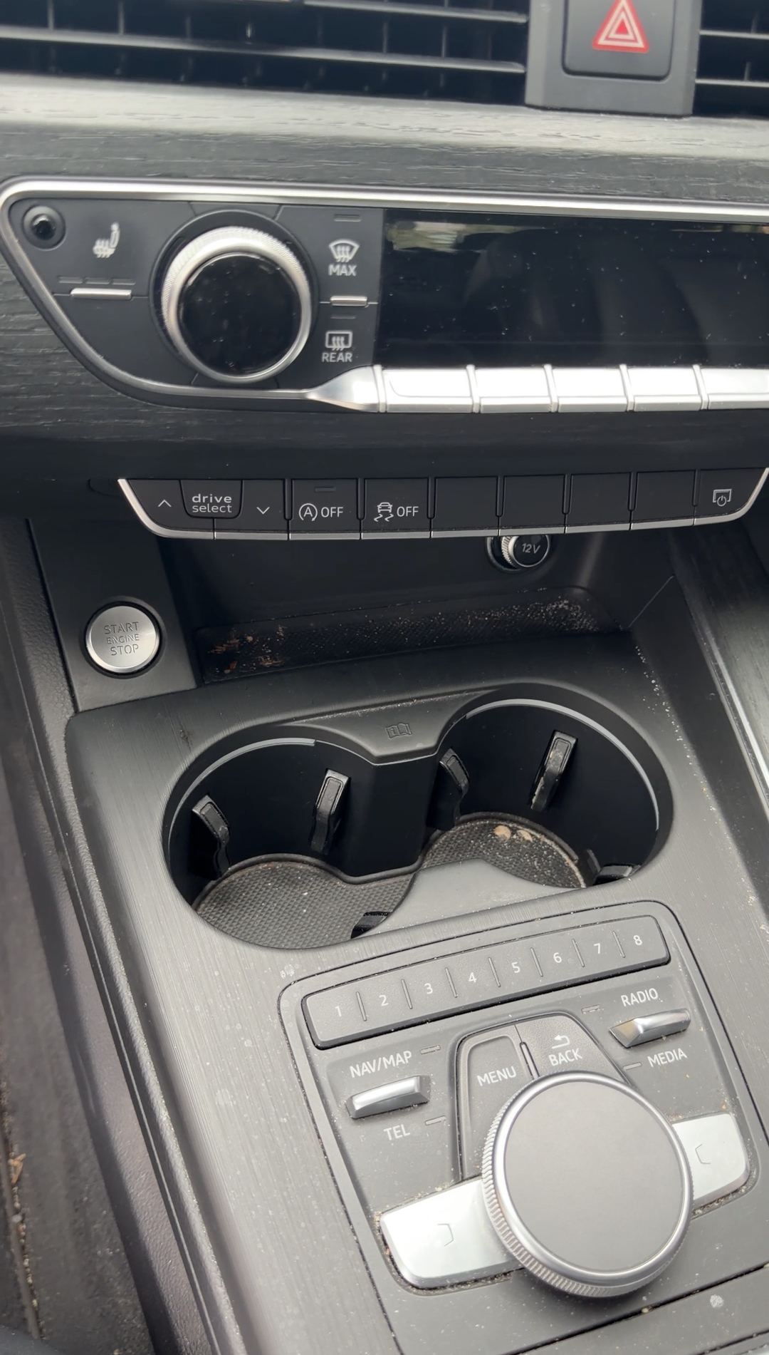 Crumbs in the cupholders of a grey Audi A4 centre console above the MMI controller