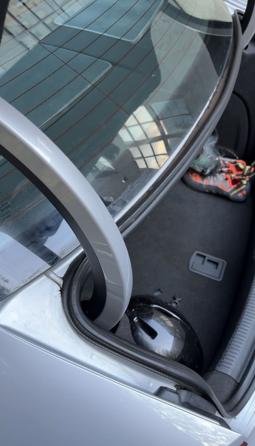 Cleared trunk rain channel and hinge on a silver Audi A3 with clean rear glass