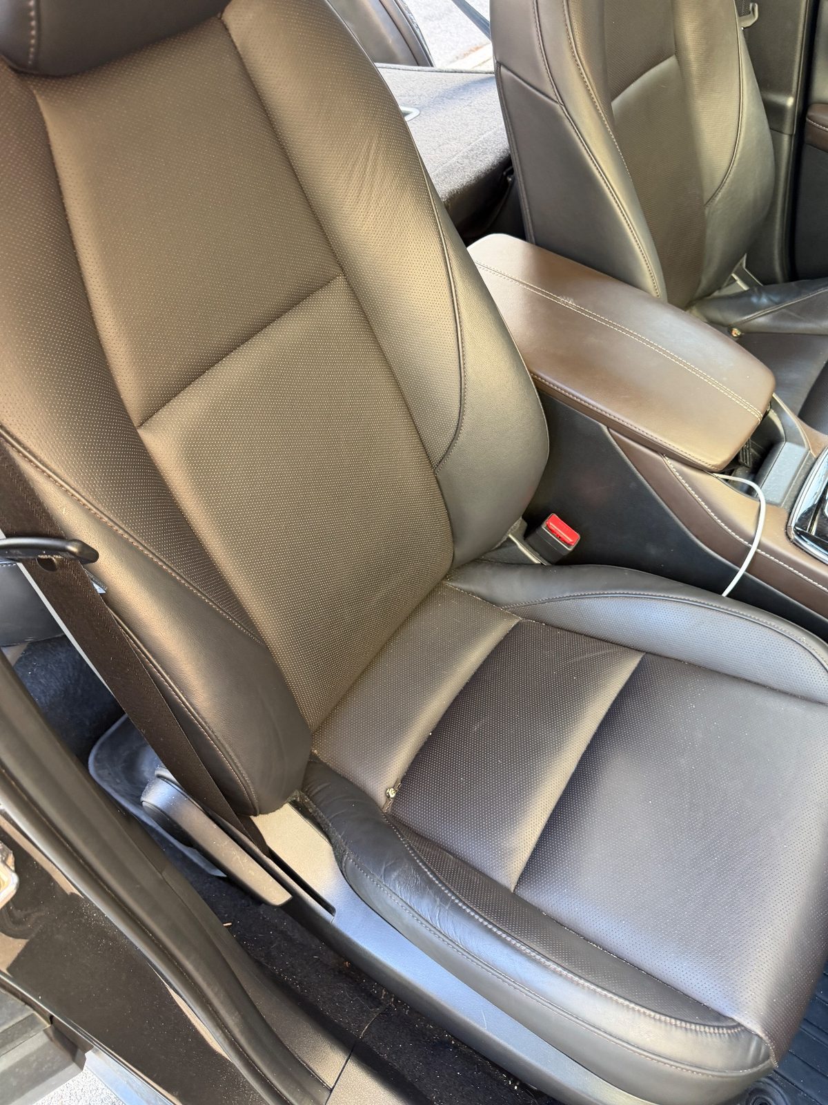 Front passenger seat of a grey Mazda CX-30 before detailing, leather dusty and armrest dull