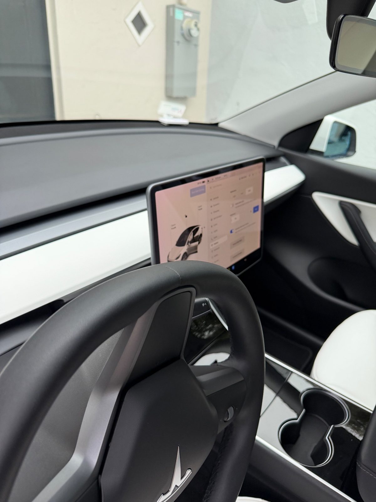 Dashboard and steering wheel of a white Tesla Model Y after detailing