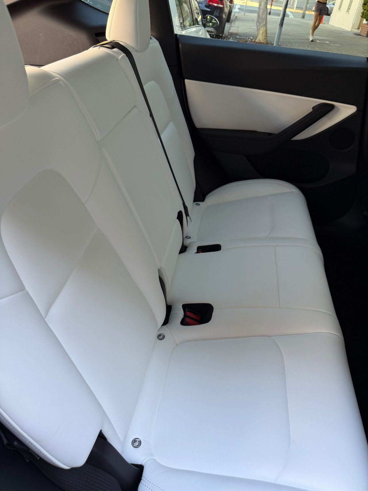 Clean white leather rear seat of a Tesla Model Y after detailing