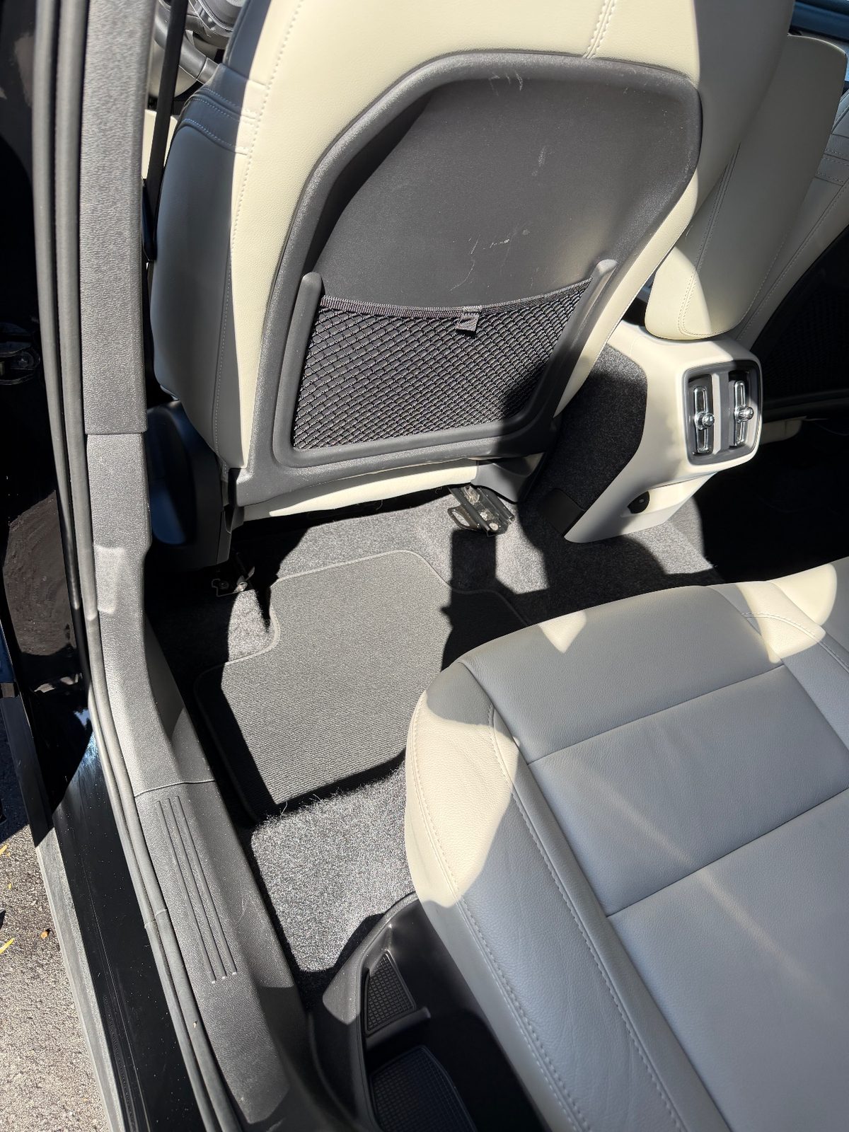 Vacuumed rear footwell of a Volvo XC40 after detailing, with clean mat and carpet