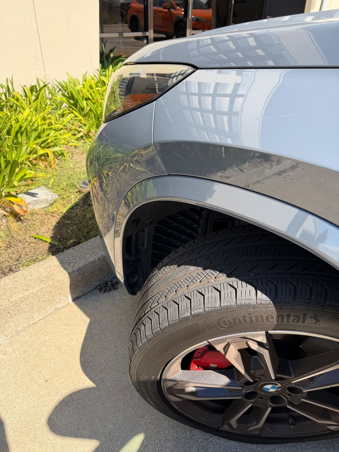 Front fender and wheel of a grey BMW X1 before washing