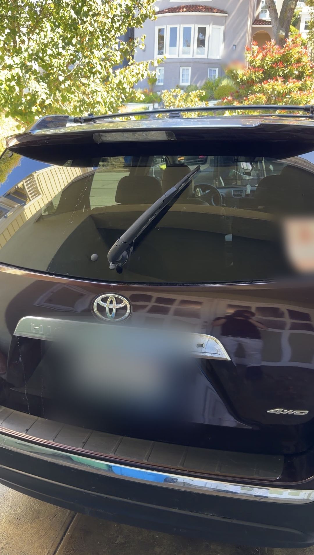 Clean rear tailgate of a plum Toyota Highlander with HIGHLANDER badging