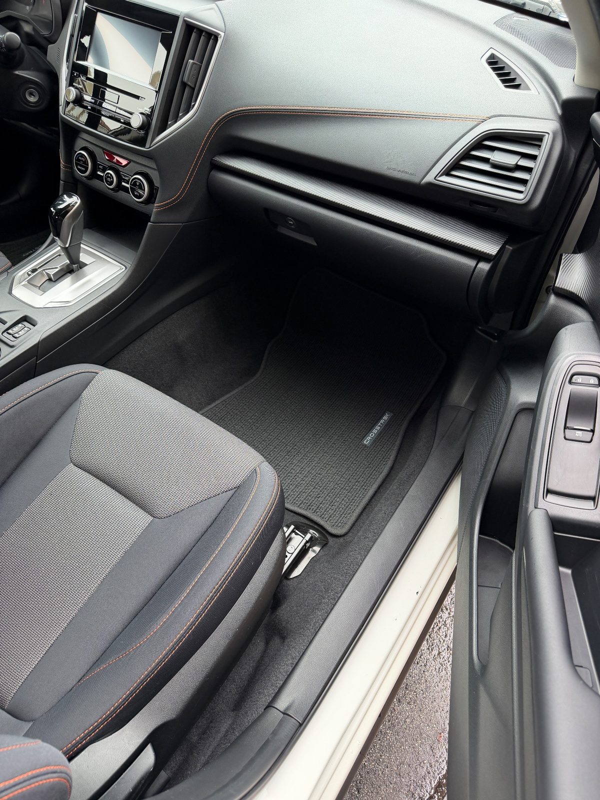 Clean front passenger footwell and dash of a Subaru Crosstrek after vacuuming