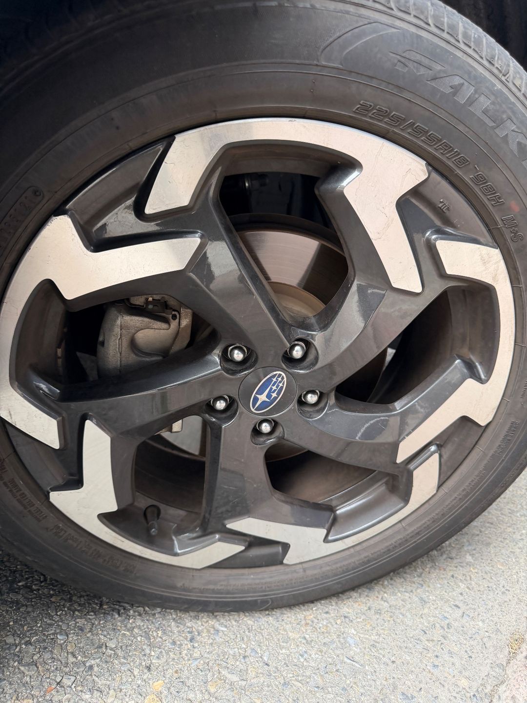 Machined alloy wheel of a Subaru Crosstrek before cleaning, with brake dust on the dark spokes
