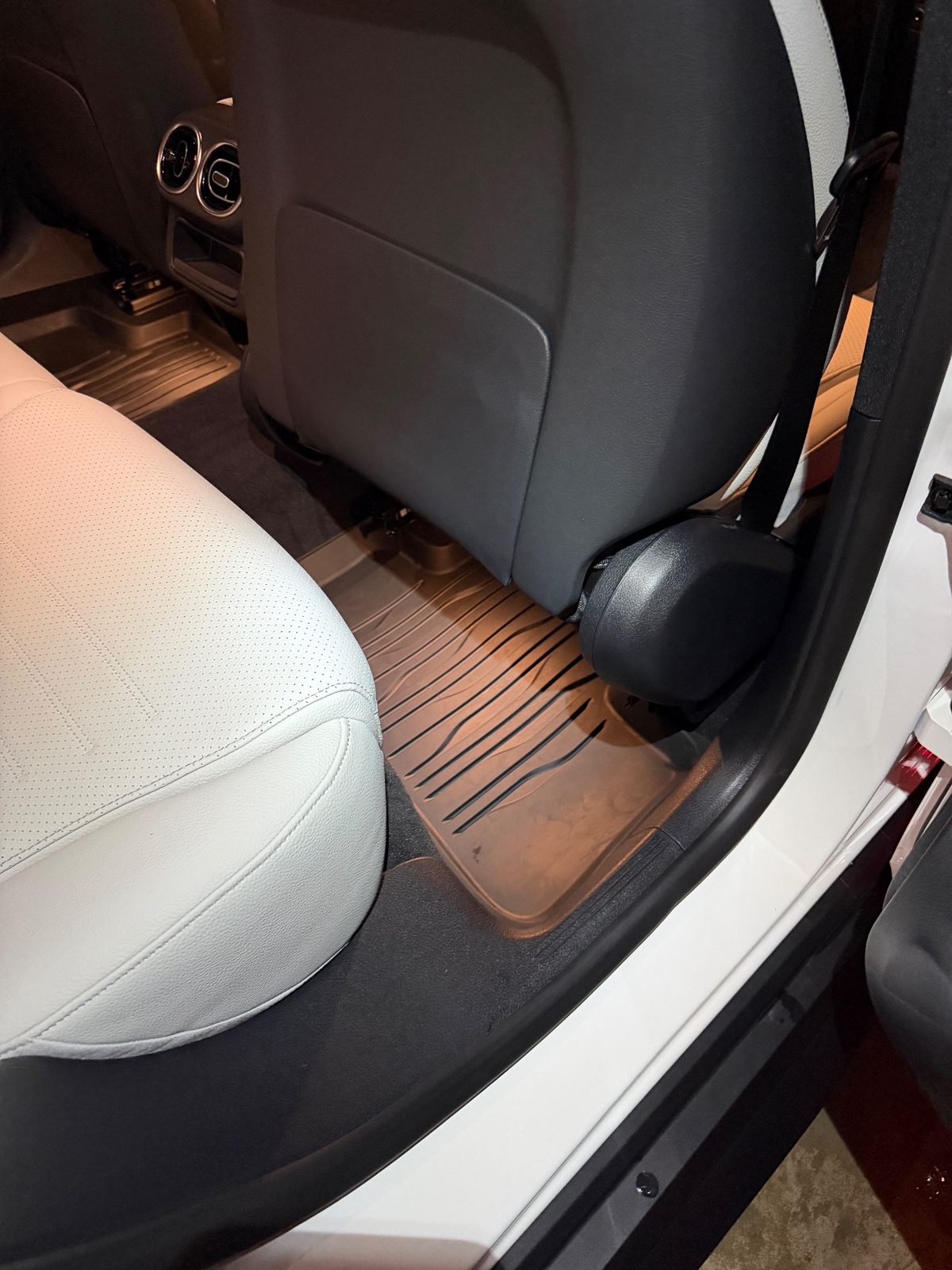 Rear footwell of a white Mercedes GLC after detailing, clean rubber mat
