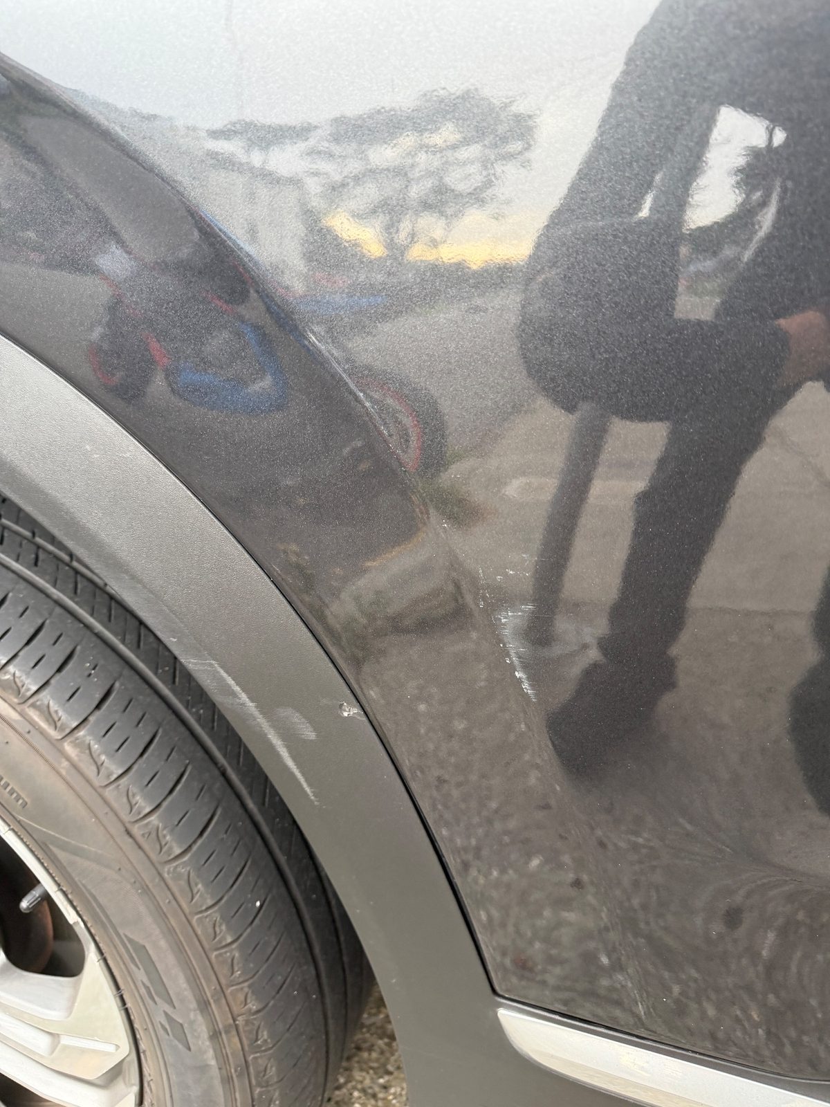 Scuffs on the wheel-arch flare and fender of a grey Hyundai Santa Fe before detailing