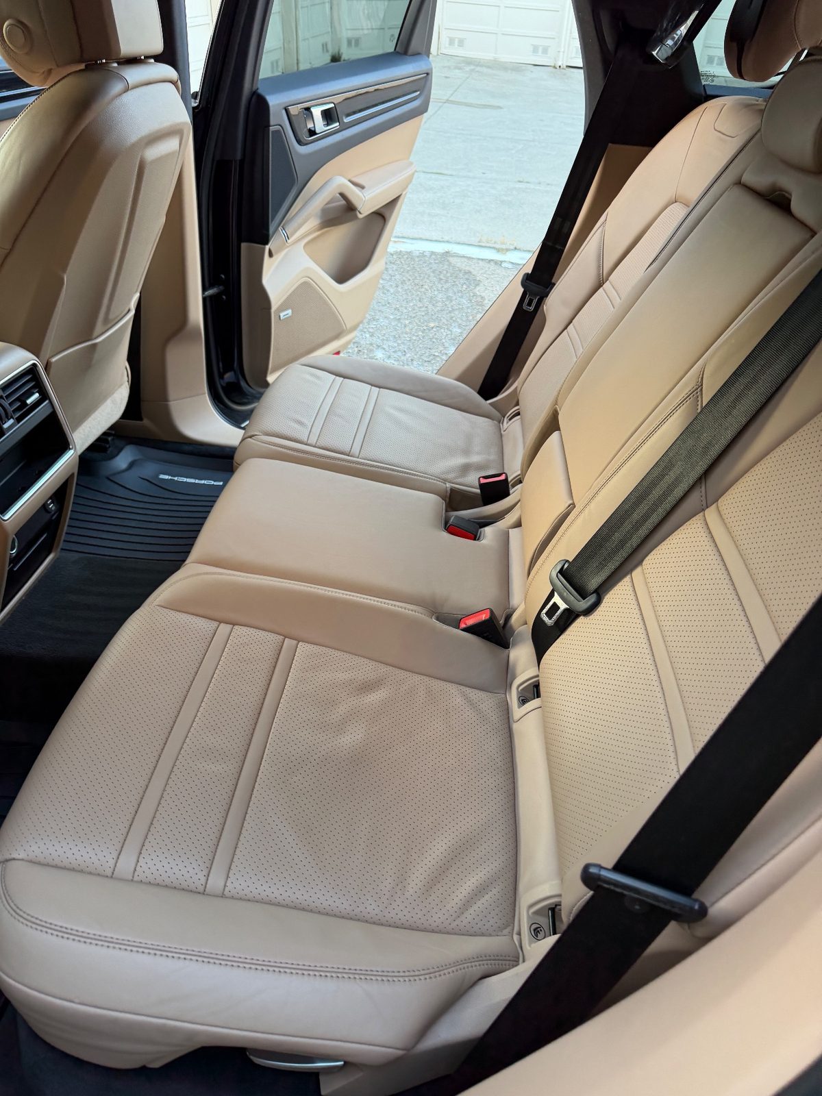 Clean rear seat of a Porsche Cayenne after detailing, leather free of dull grime