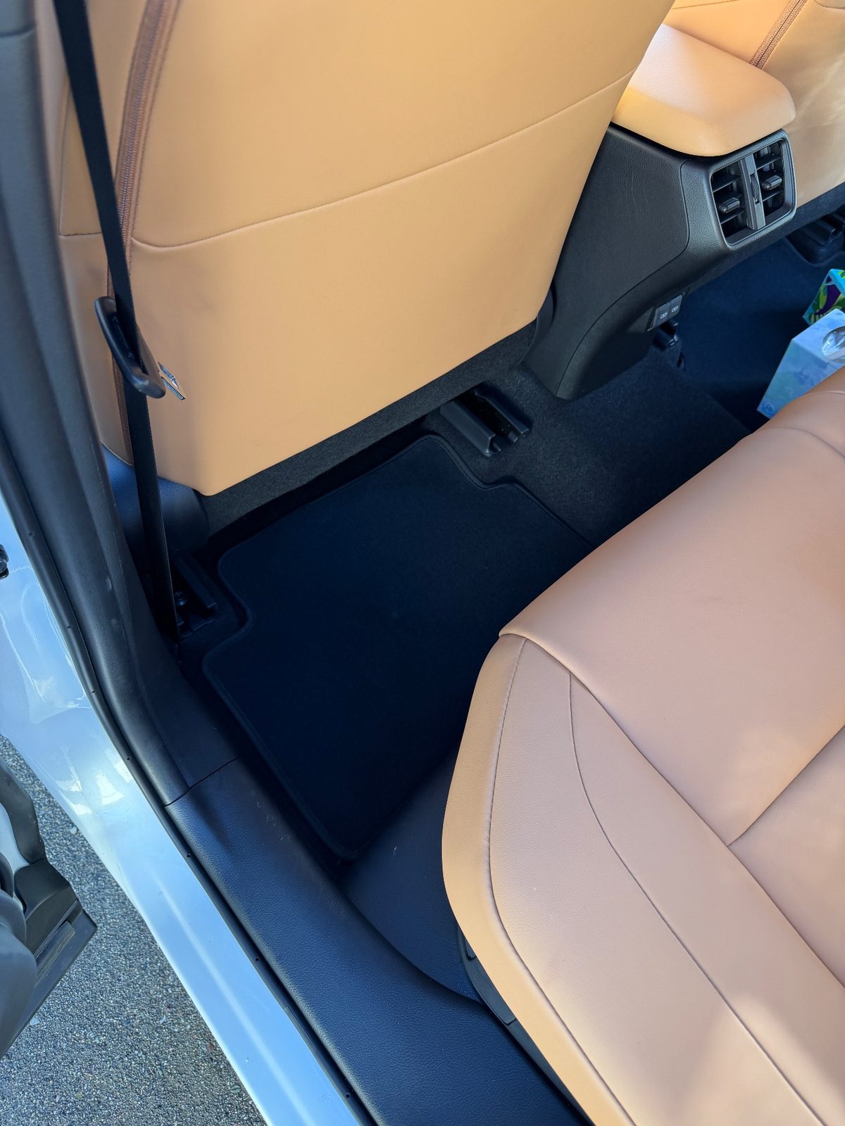 Clean rear footwell of a white Lexus UX after detailing, mat free of crumbs