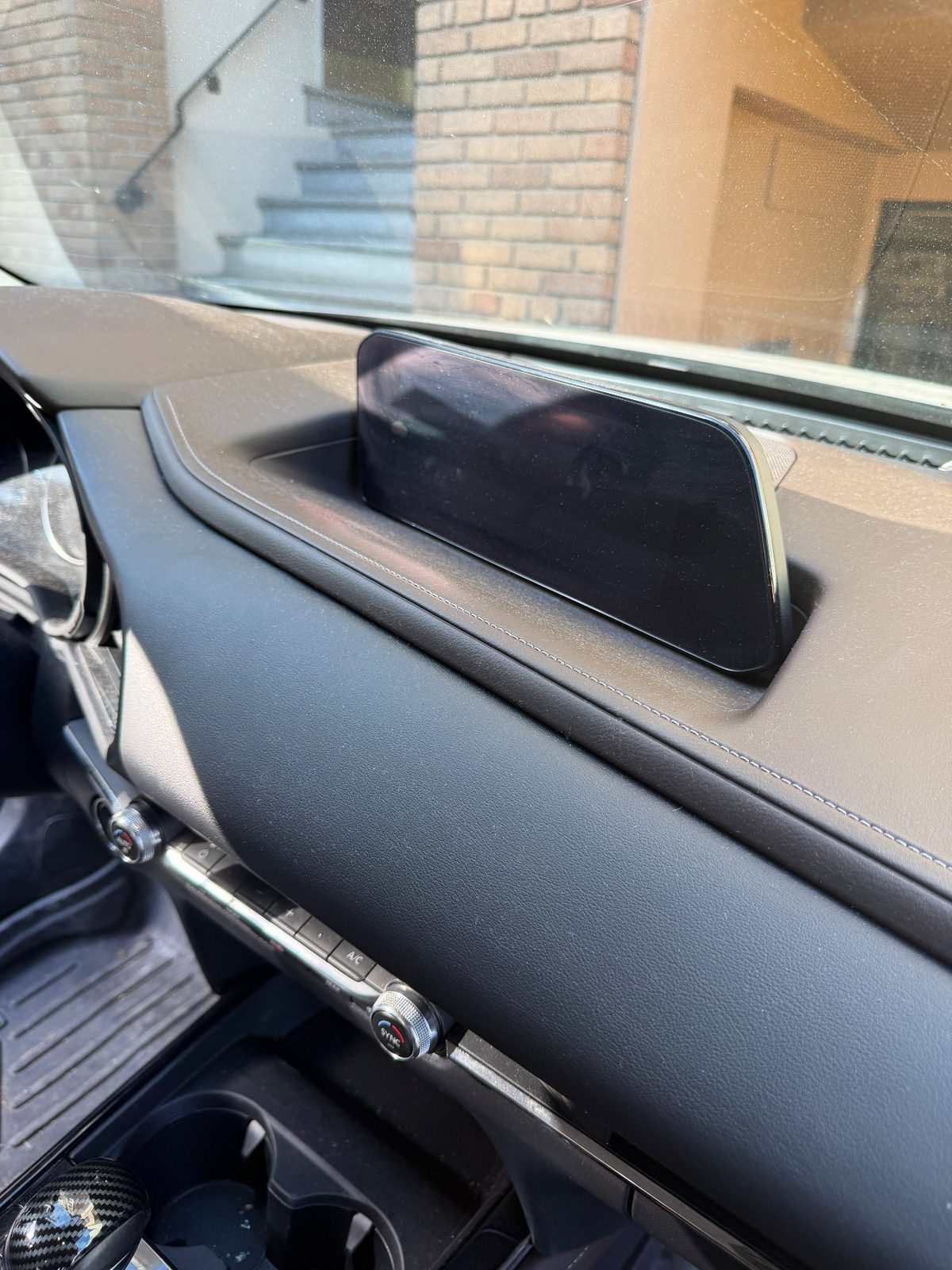 Dashboard and screen of a grey Mazda CX-30 before cleaning with dust and fingerprints