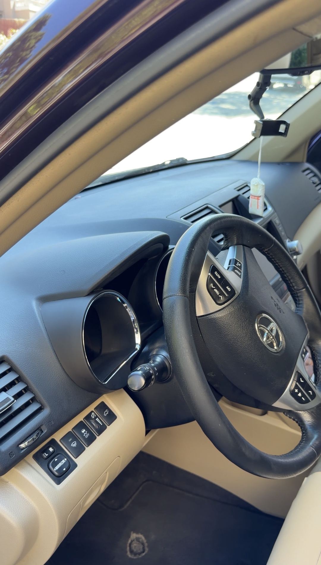 Clean dashboard and steering wheel of a Toyota Highlander seen from the driver door