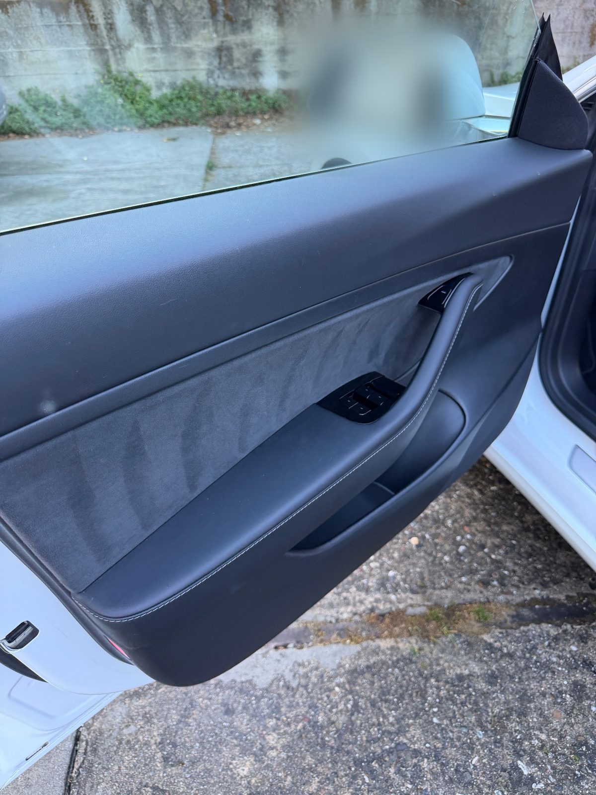 Clean door card of a white Tesla Model 3 after detailing