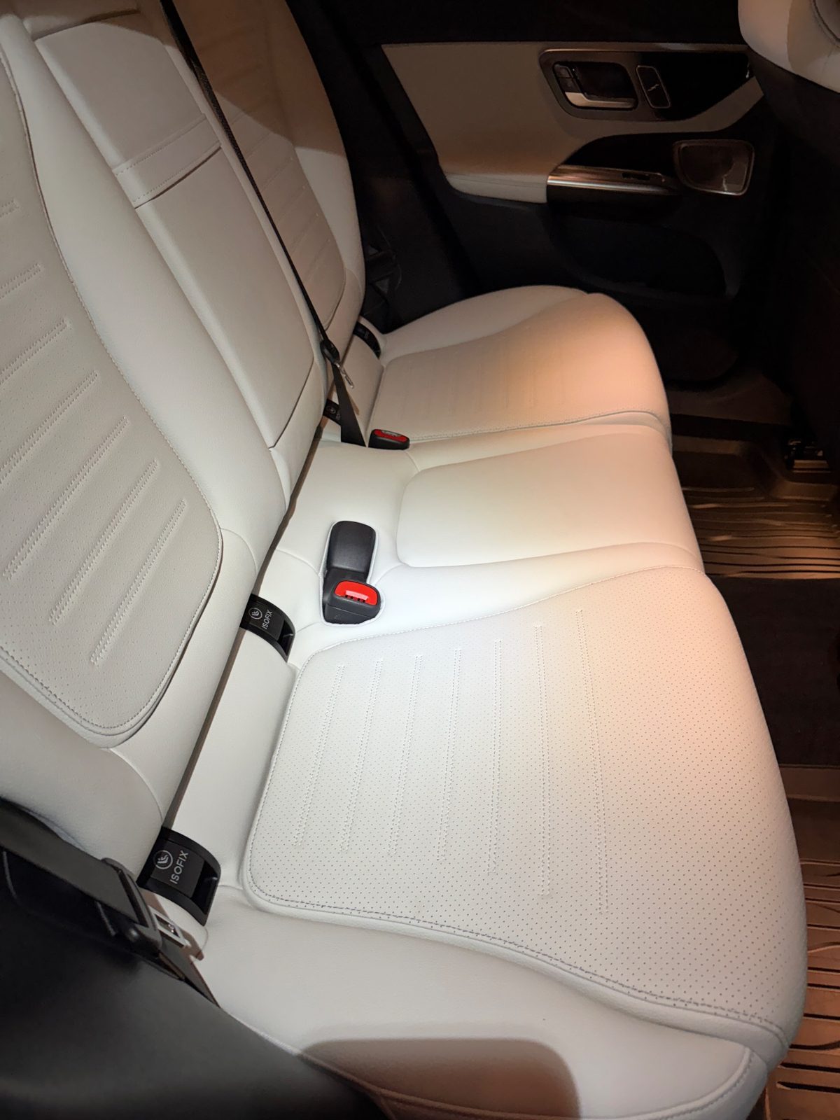 Rear bench seat of a white Mercedes GLC after cleaning, bright clean leather