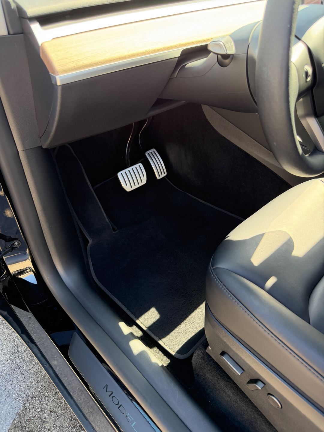 Driver footwell and alloy pedals of a Tesla Model Y Performance after detailing