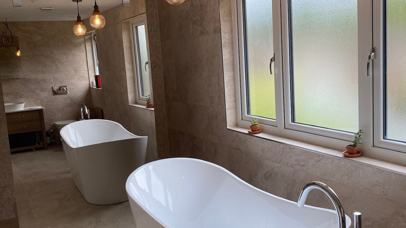 Bathroom with warm globe pendant lights and freestanding bath — LED atmosphere lighting installation