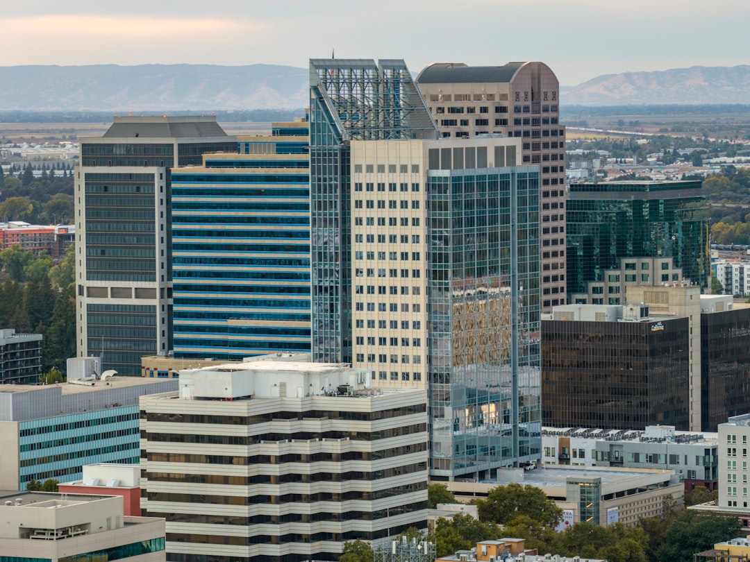 Aerial view of downtown Sacramento office towers at dusk with low hills on the horizon.