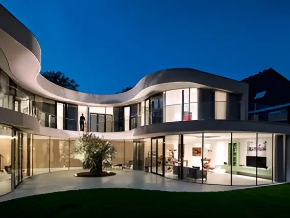 Modern home at dusk with warm interior and exterior lighting