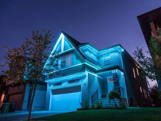 Two storey house at night with blue permanent LED trim lighting along the roofline