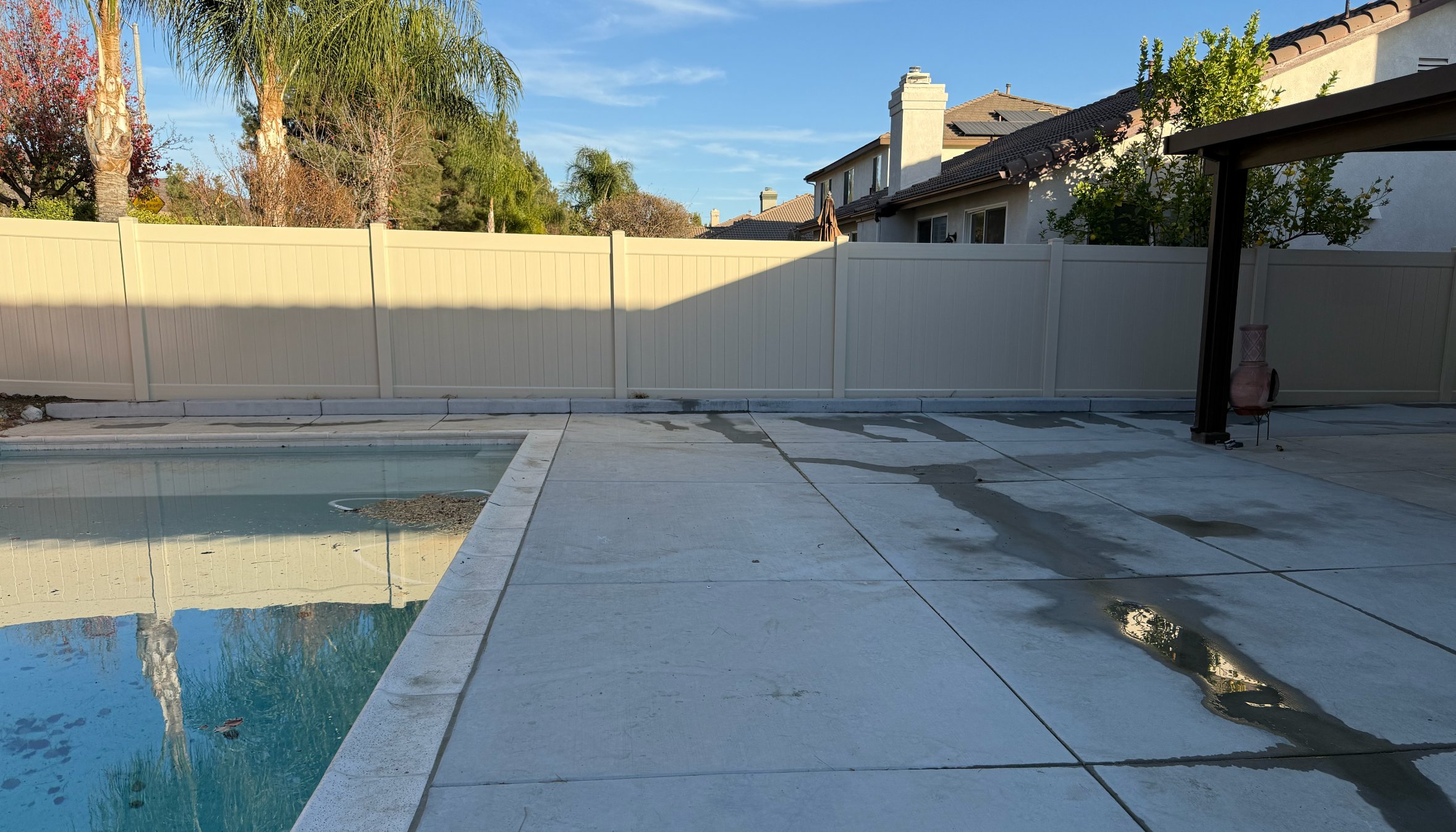 Tan vinyl privacy fence beside covered patio in Temecula, California