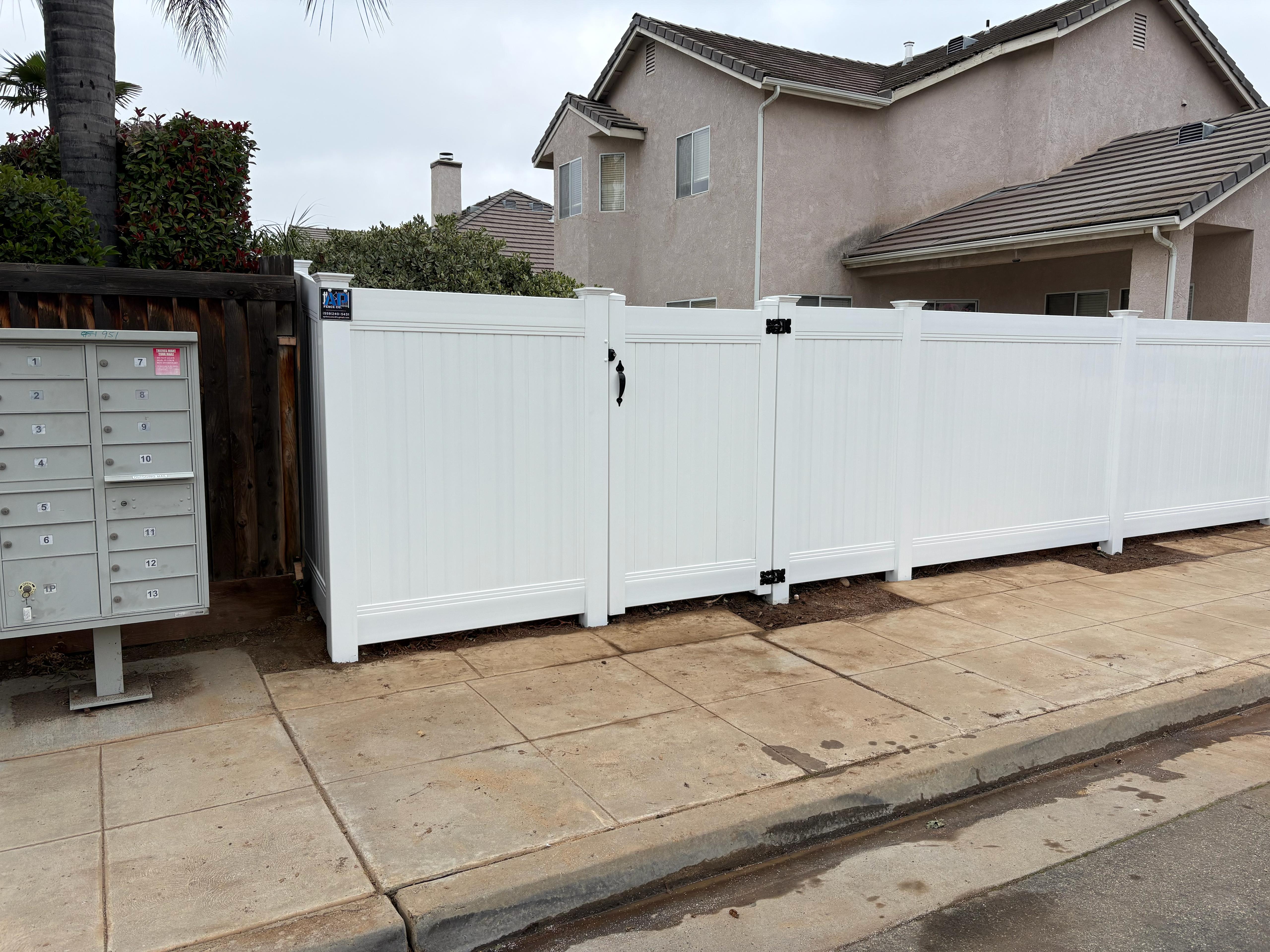 White vinyl double-drive gate installation in Lake Elsinore, California