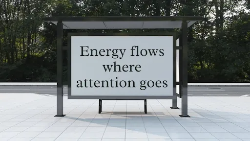 Bus shelter billboard reading Energy flows where attention goes