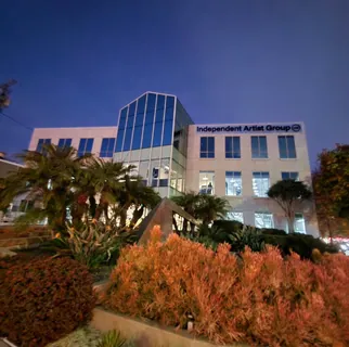 An office building at dusk with tinted window glazing across its upper floors.