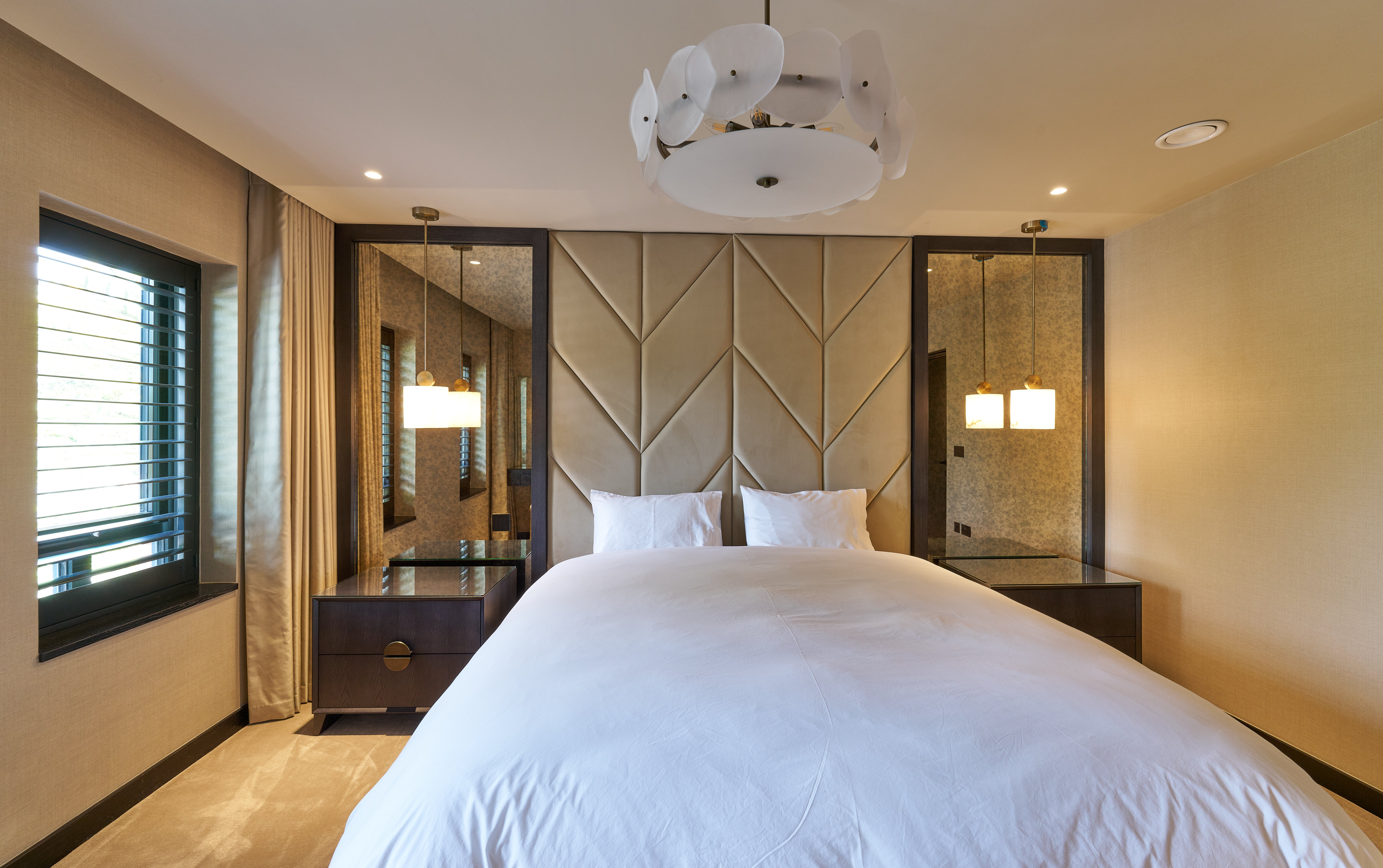 Antique framed mirrors flanking a luxury bed