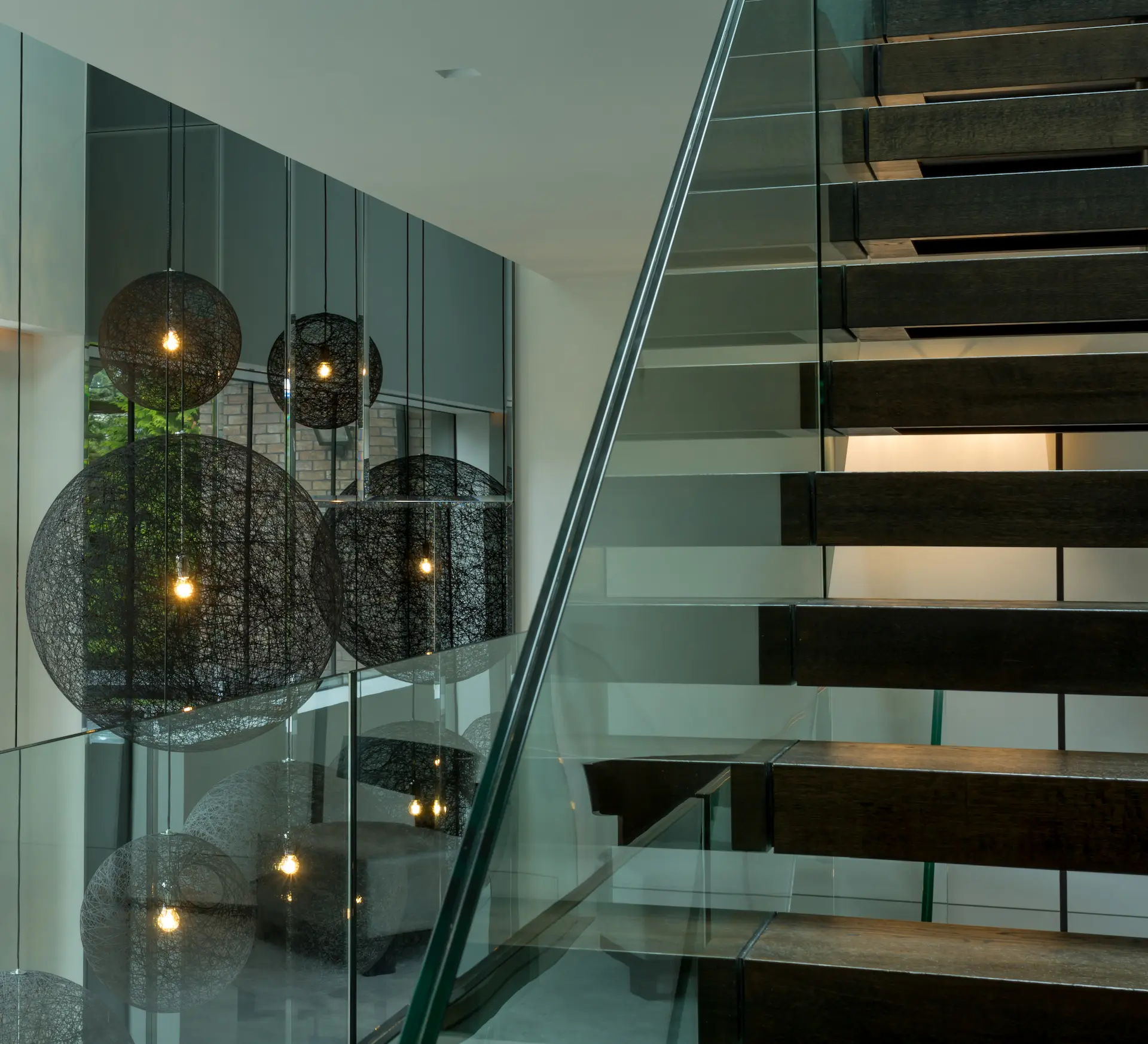 Full-height glass mirror wall alongside staircase