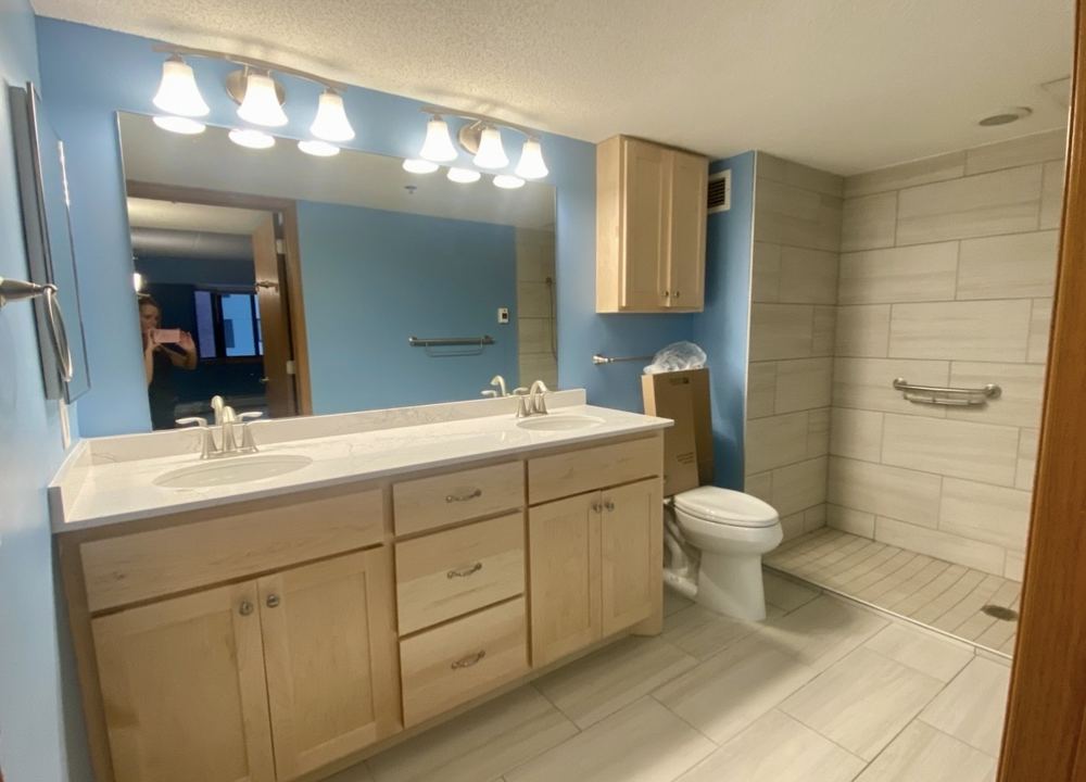 Bathroom vanity, mirror, and tile shower after cleaning