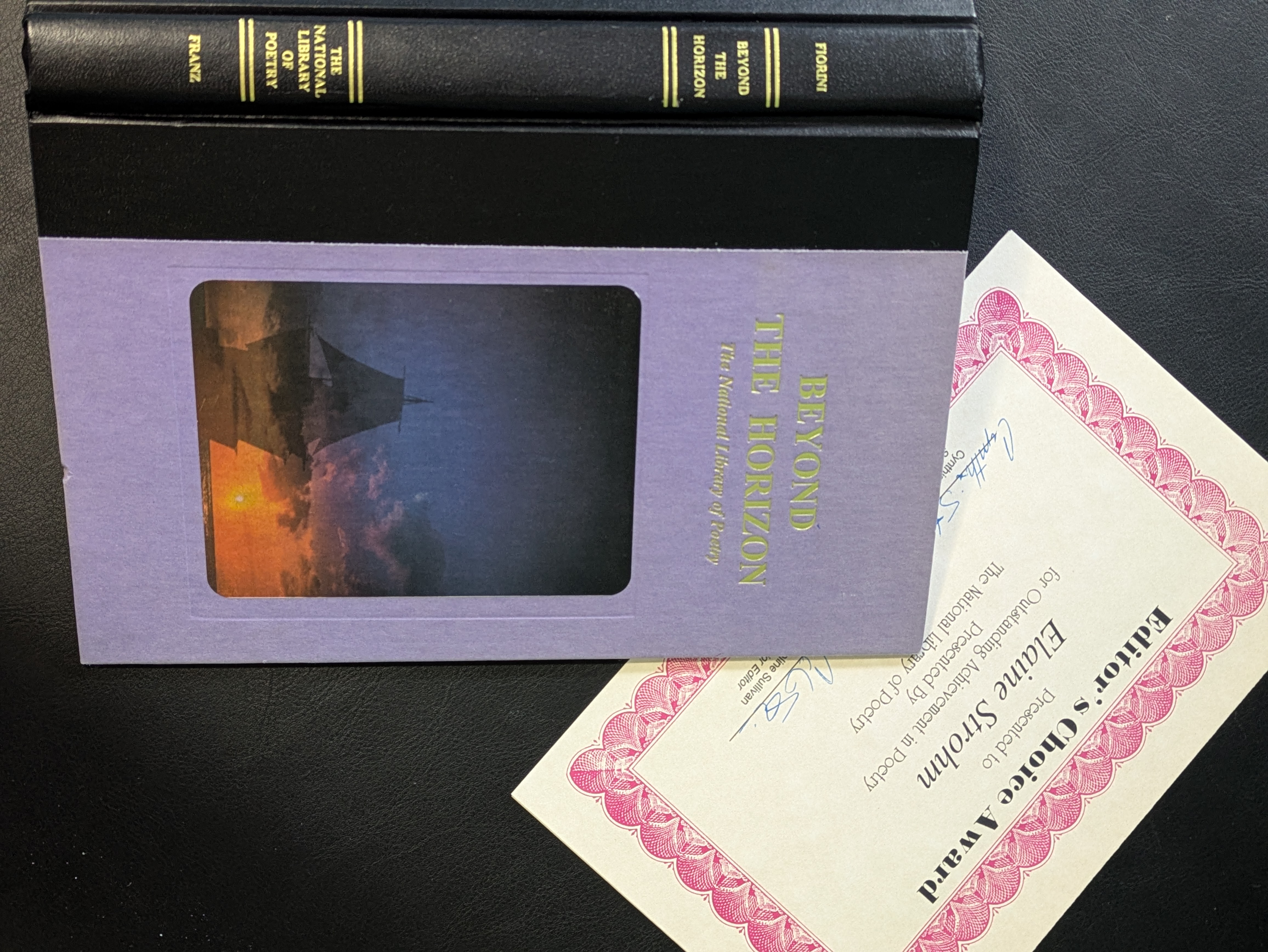 The cover of a Poetry Anthology with an award certificate.