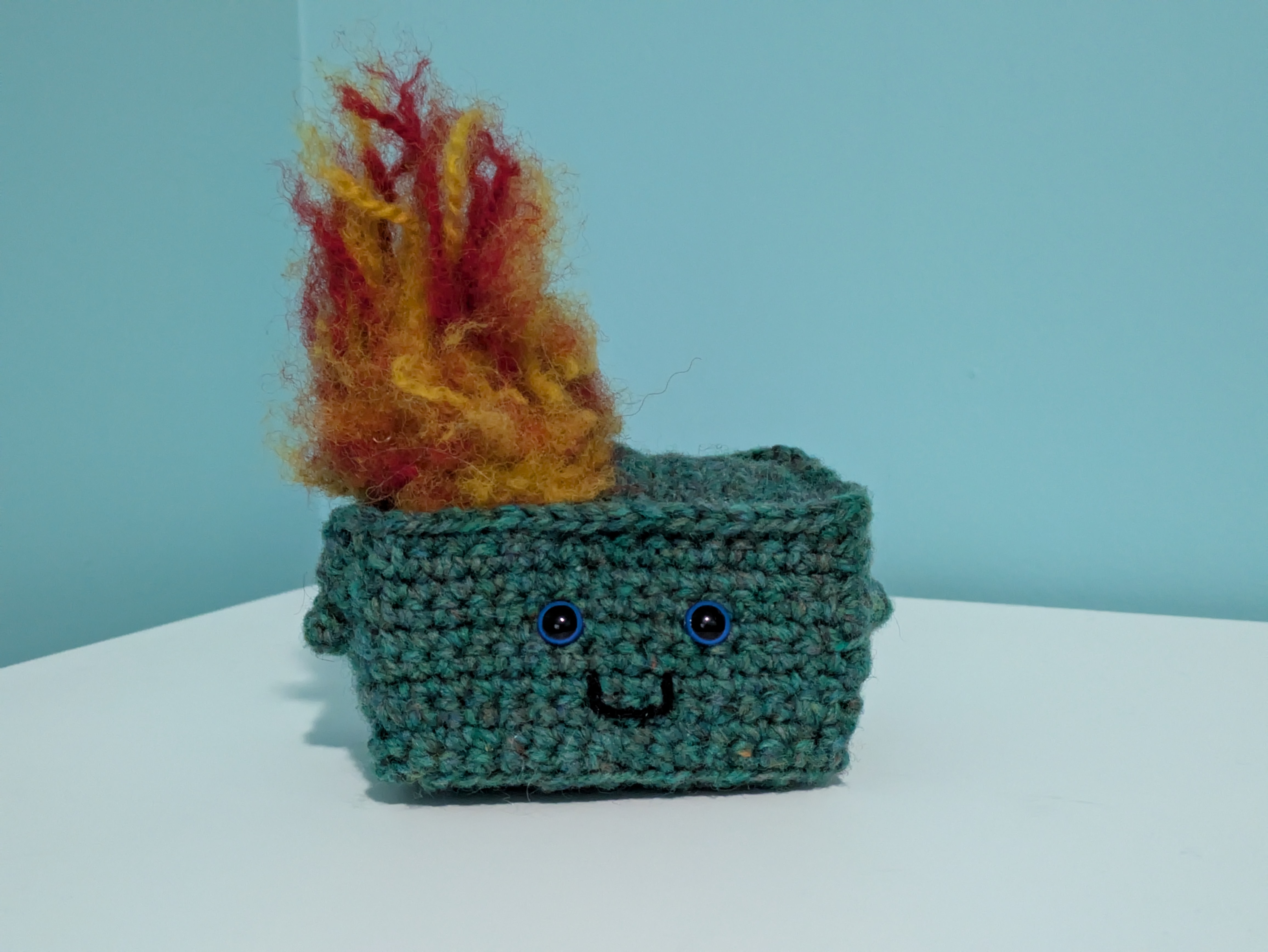 A cute crochet dumpster fire has a smiling face A cute crochet dumpster fire has a smiling face